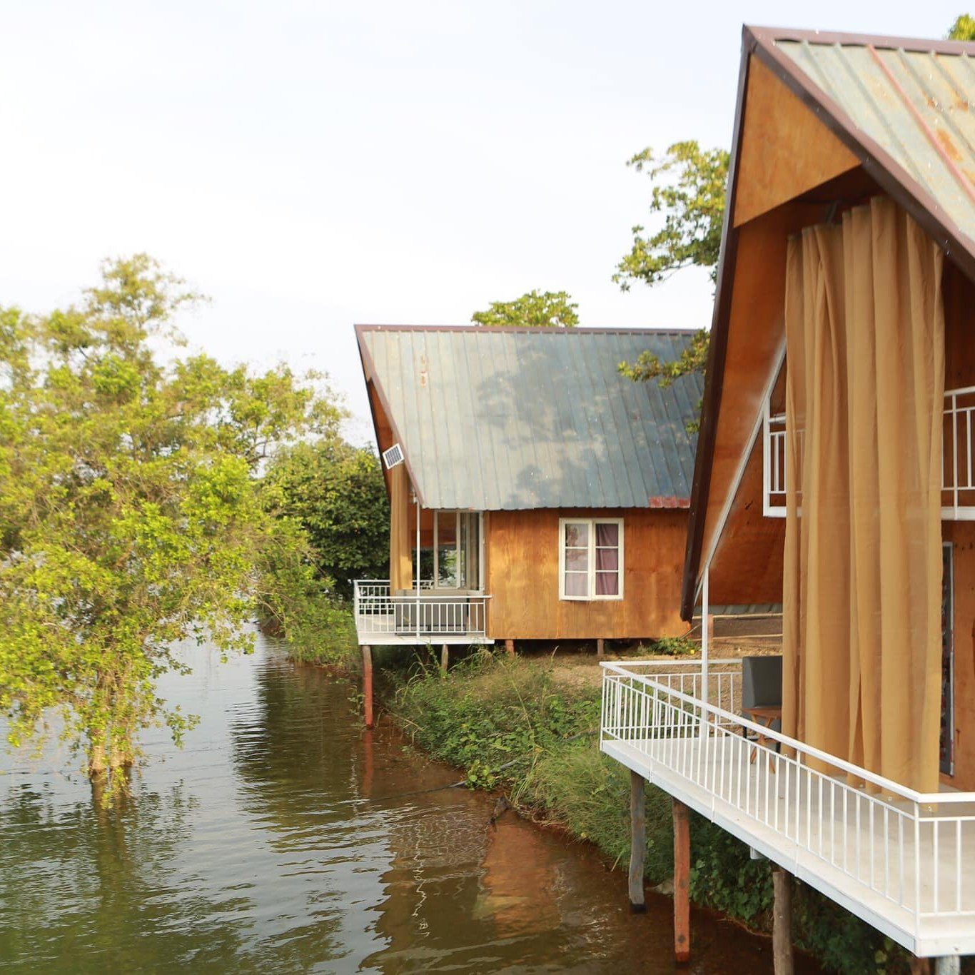 Bungalow gỗ soi bóng xuống mặt nước mùa nước lên
